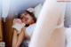 A woman laying in bed with a stuffed animal.