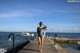 A woman in a bathing suit standing on a pier.