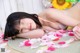 A young woman laying on the floor surrounded by petals.